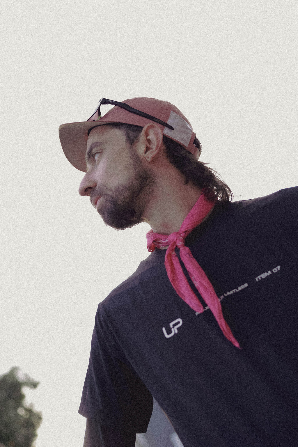 Man wearing a pink cap and pink UP bandana and an UP Active shirt. 