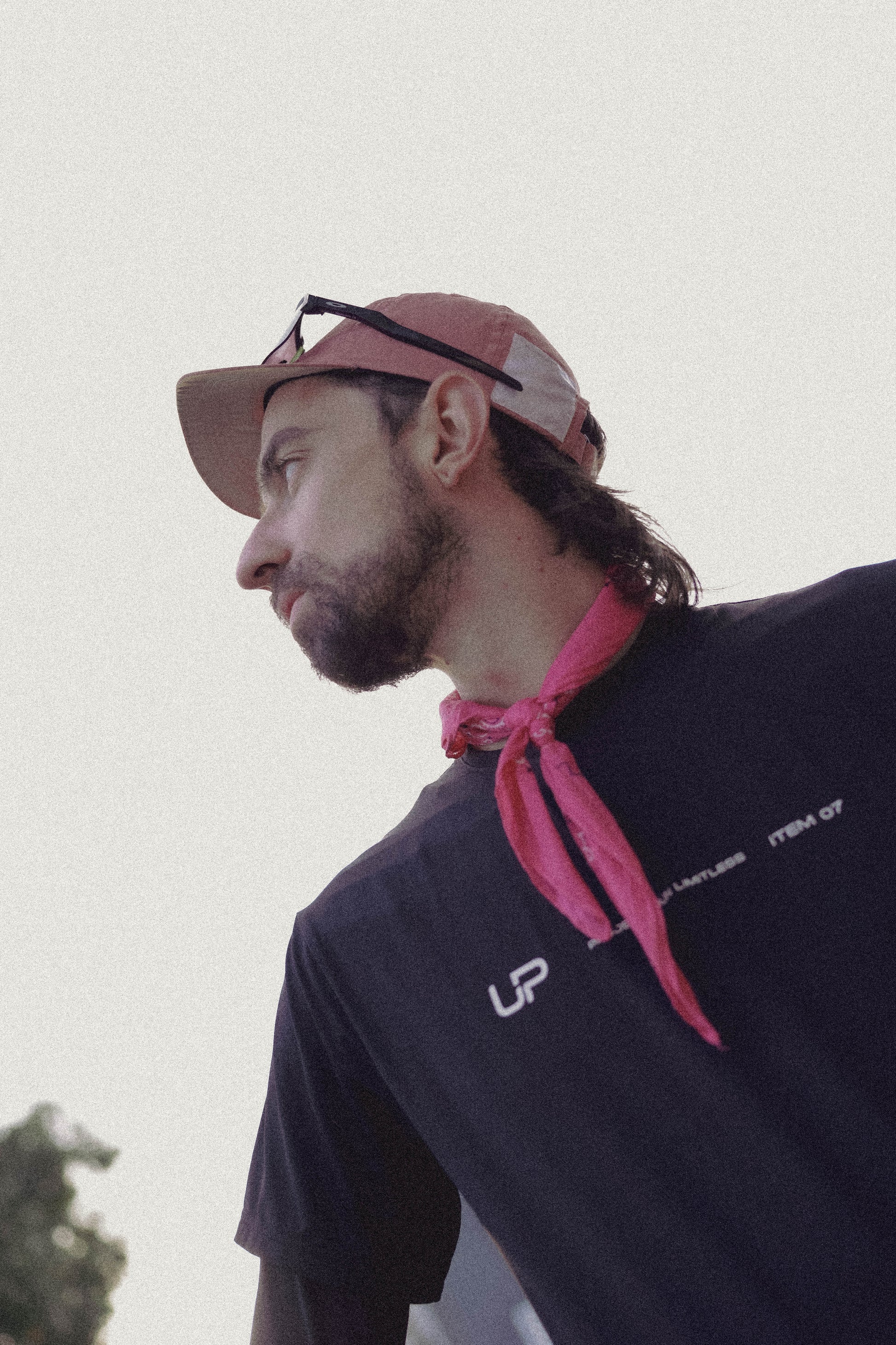 Man wearing a pink cap and pink UP bandana and an UP Active shirt. 