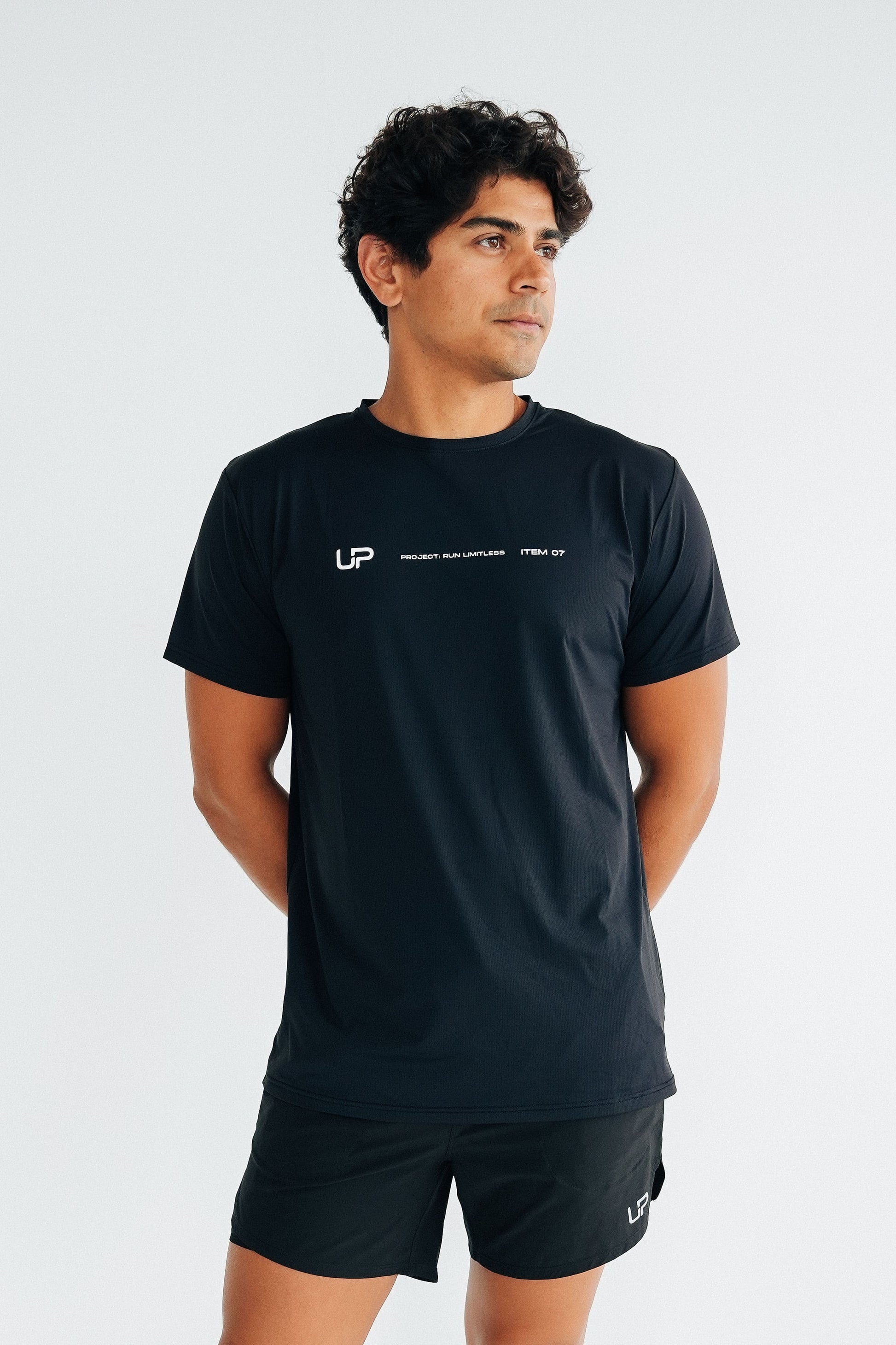 A man wearing a black performance tee from UP Active and running shorts by UP.
